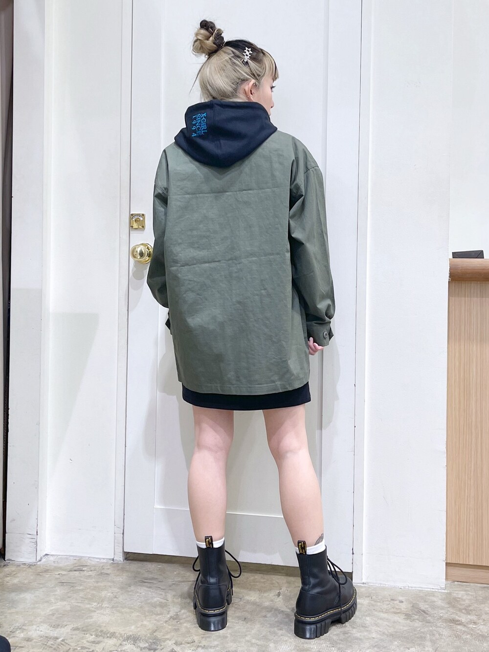 グリーン系のミリタリージャケット、ブラック系のワンピース、ブラック系のショルダーバッグを着用したレディースの冬コーディネートの4枚目の写真