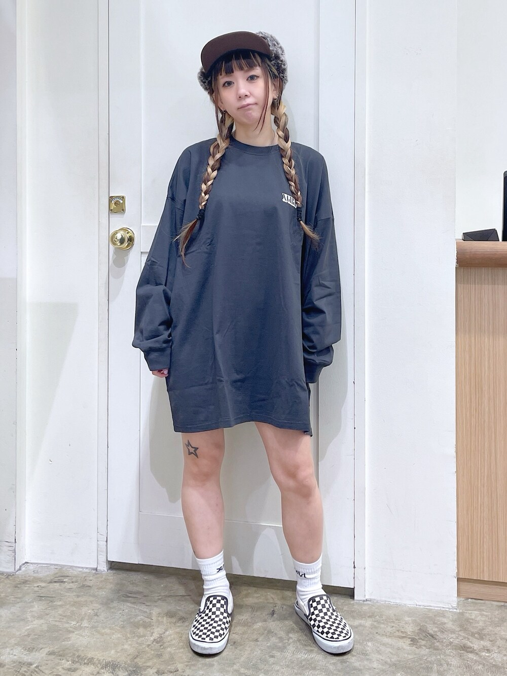 グレー系のワンピース、ブラウン系のキャップ、ホワイト系のソックス/靴下を着用したレディースの秋コーディネートの2枚目の写真