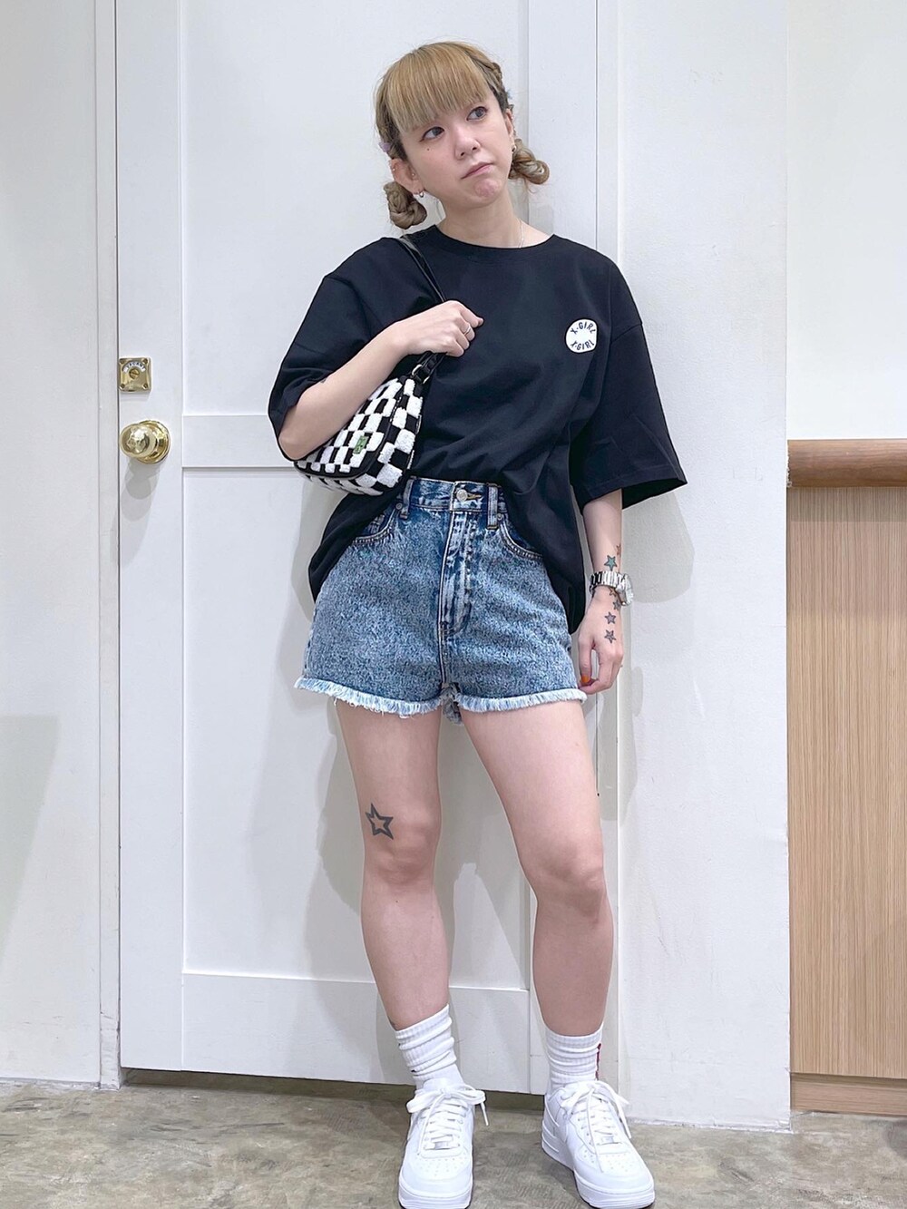 ブラック系のTシャツ/カットソー、ブルー系のデニムパンツ、ホワイト系のハンドバッグを着用したレディースの夏コーディネートの2枚目の写真