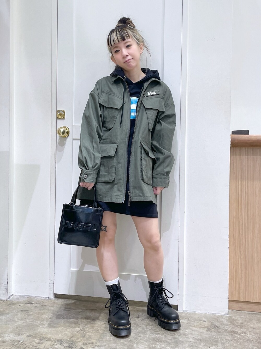 グリーン系のミリタリージャケット、ブラック系のワンピース、ブラック系のショルダーバッグを着用したレディースの冬コーディネートの2枚目の写真