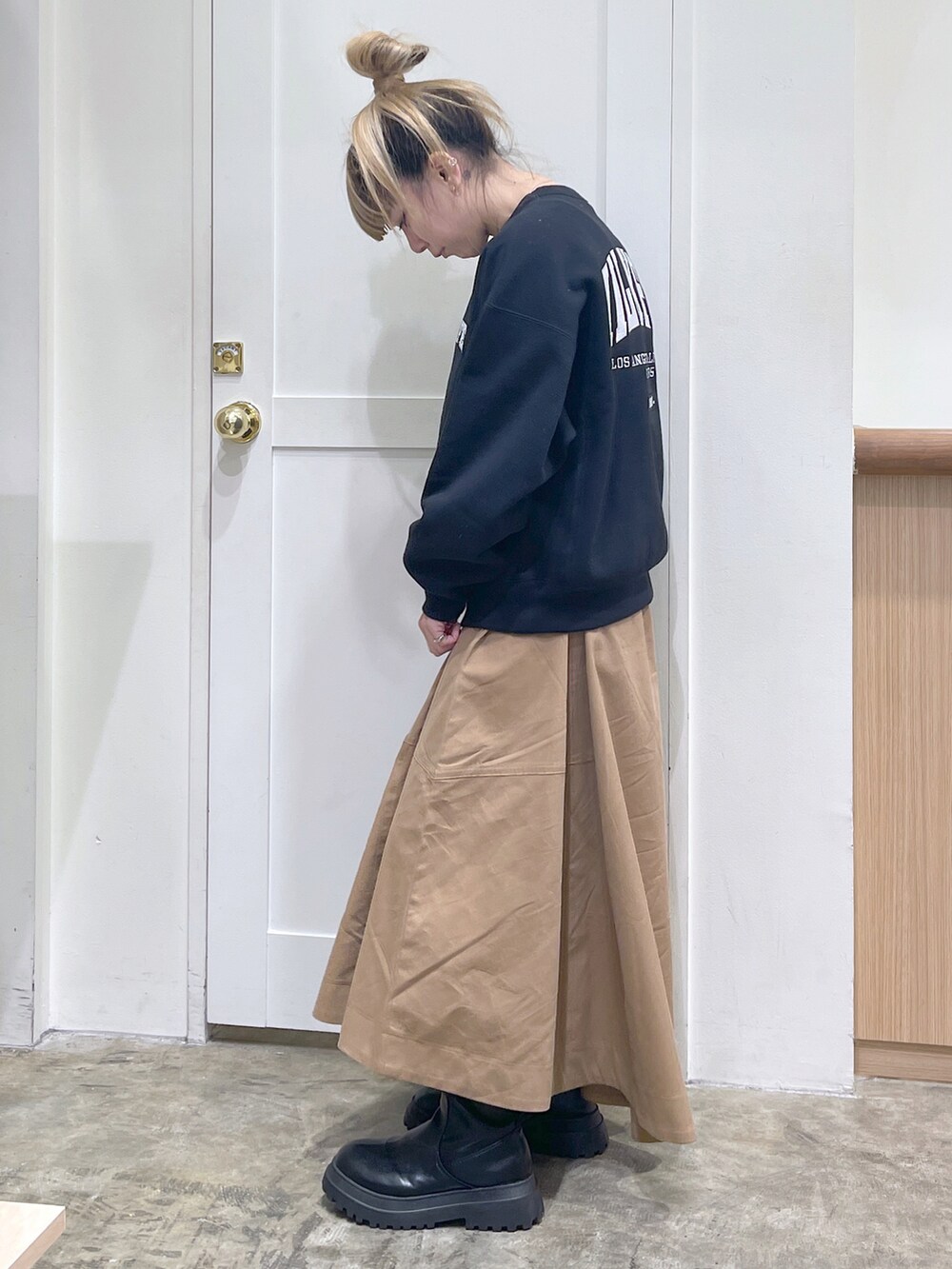 ブラック系のスウェット、ベージュ系のスカート、ブラック系のボディバッグ/ウエストポーチを着用したレディースの秋コーディネートの4枚目の写真