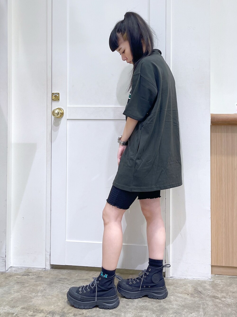 グレー系のワンピース、ピンク系のショルダーバッグ、ブラック系のスニーカーを着用したレディースの夏コーディネートの3枚目の写真