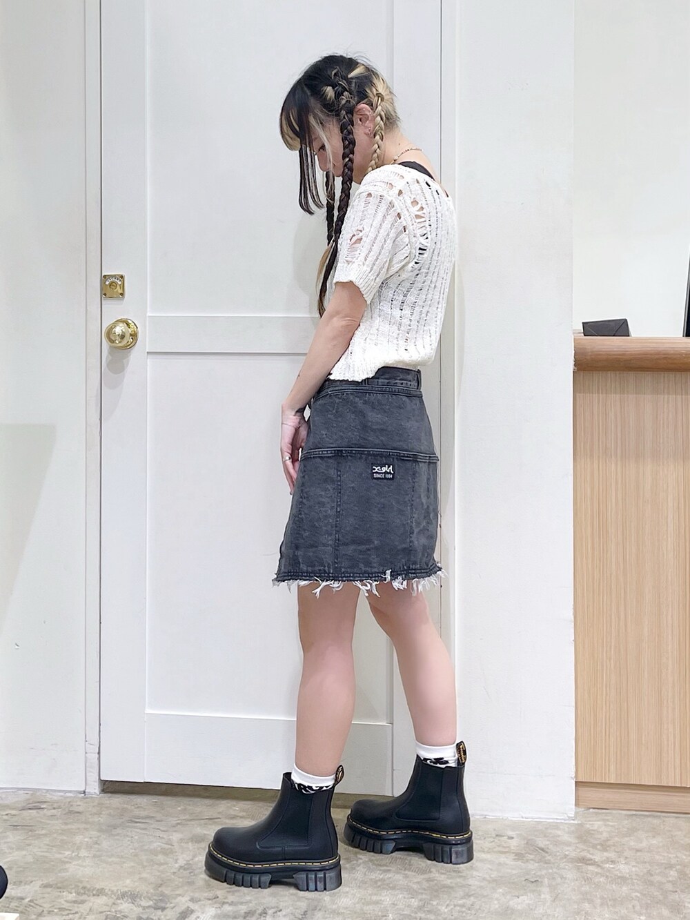 ホワイト系のニット/セーター、ブラック系のタンクトップ、ブルー系のショルダーバッグを着用したレディースの春コーディネートの4枚目の写真