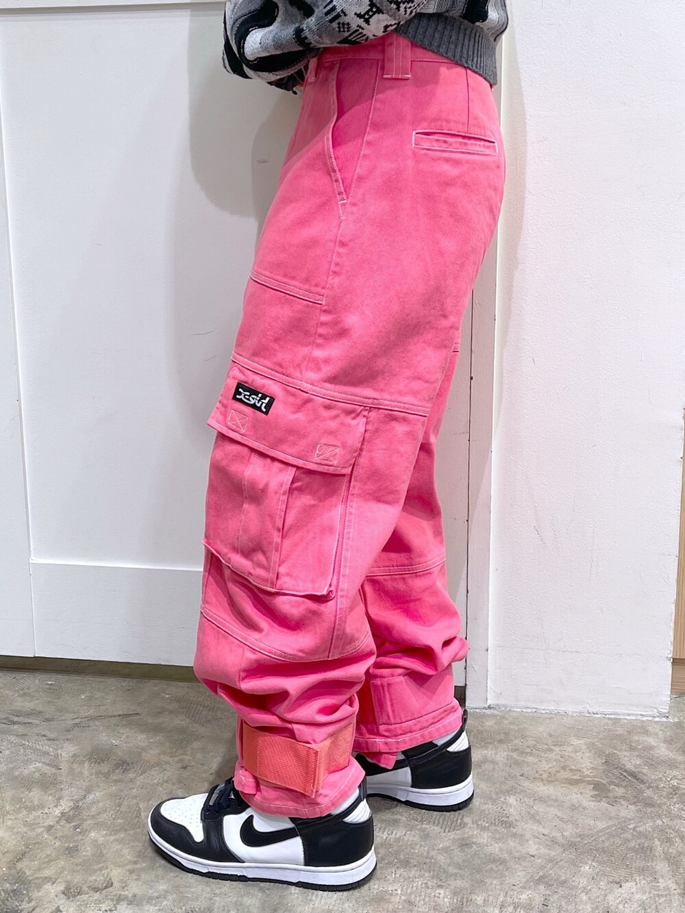 ブラック系のニット/セーター、ブラック系のメッセンジャーバッグ、ピンク系のカーゴパンツを着用したレディースの秋コーディネートの6枚目の写真