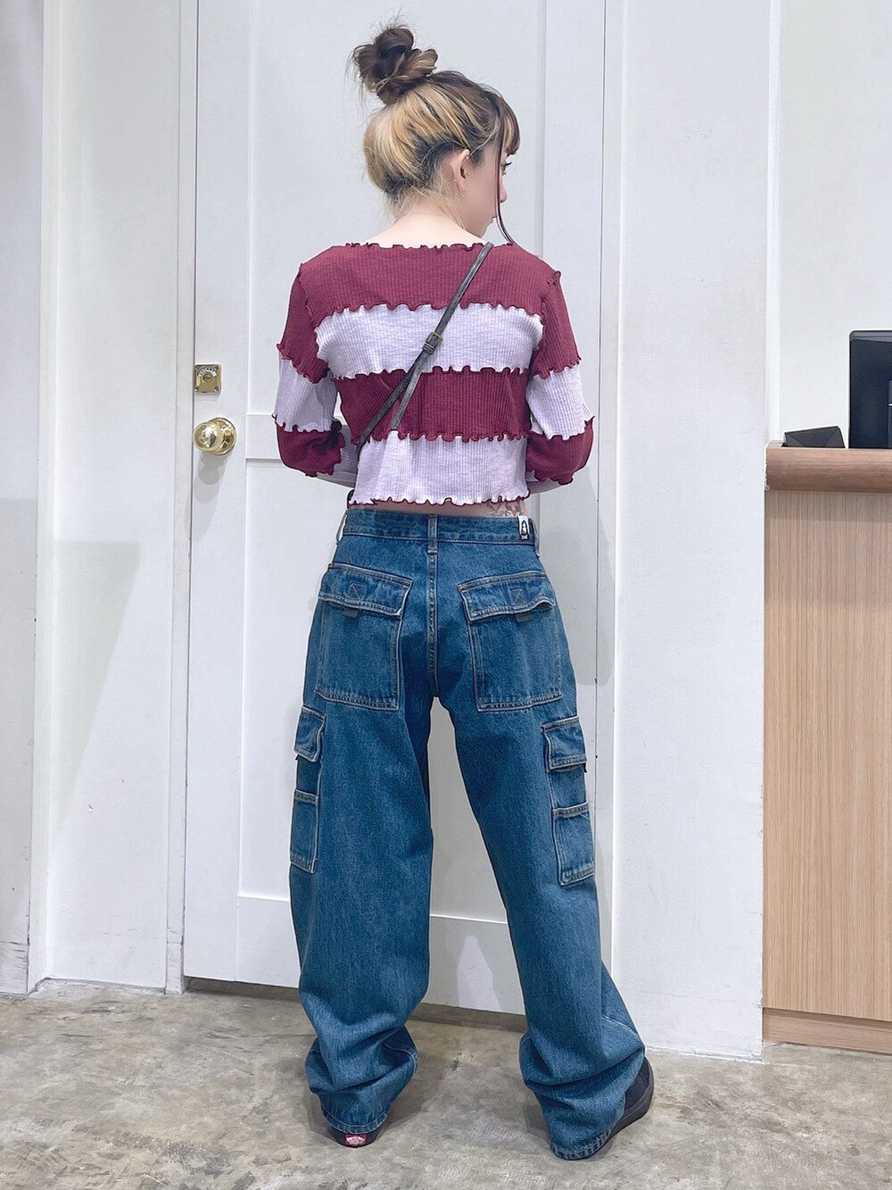 レッド系のTシャツ/カットソー、ブルー系のカーゴパンツ、ゴールド系のコインケースを着用したレディースの秋コーディネートの4枚目の写真