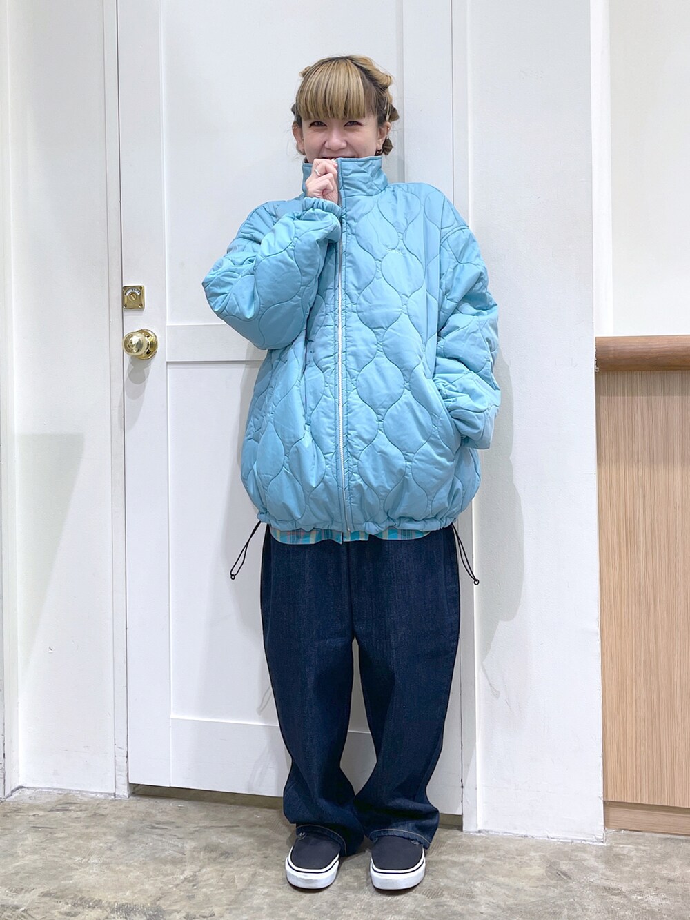 ホワイト系のナイロンジャケット、ブルー系のシャツ/ブラウス、ブルー系のデニムパンツを着用したレディースの秋コーディネートの5枚目の写真