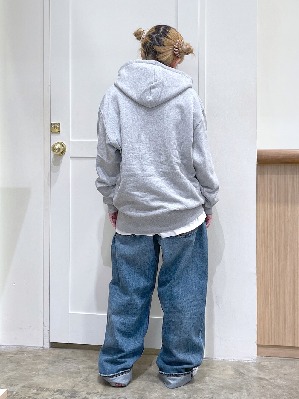 グレー系のパーカー、ブルー系のデニムパンツ、グリーン系のコインケースを着用したレディースの夏コーディネートの5枚目の写真