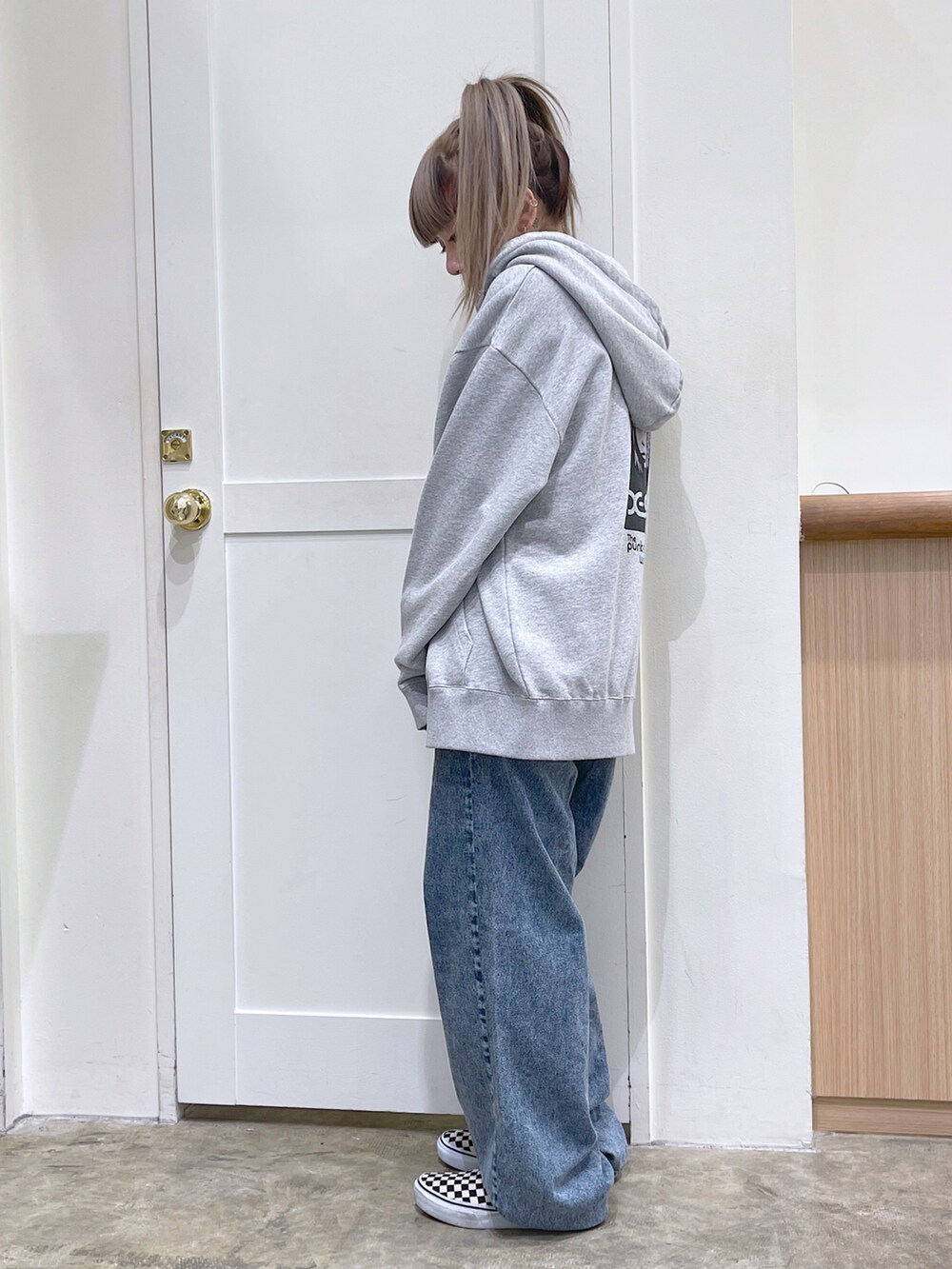 グレー系のパーカー、ブラック系のキャミソール、ブルー系のデニムパンツを着用したレディースの夏コーディネートの3枚目の写真