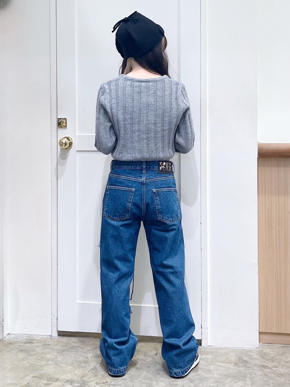 グレー系のニット/セーター、ブルー系のデニムパンツ、ブラック系のニットキャップ/ビーニーを着用したレディースの秋コーディネートの4枚目の写真