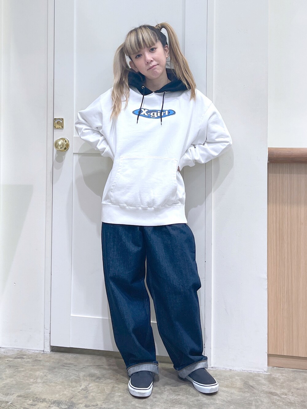 ブルー系のブルゾン、ホワイト系のパーカー、ブルー系のデニムパンツを着用したレディースの秋コーディネートの4枚目の写真