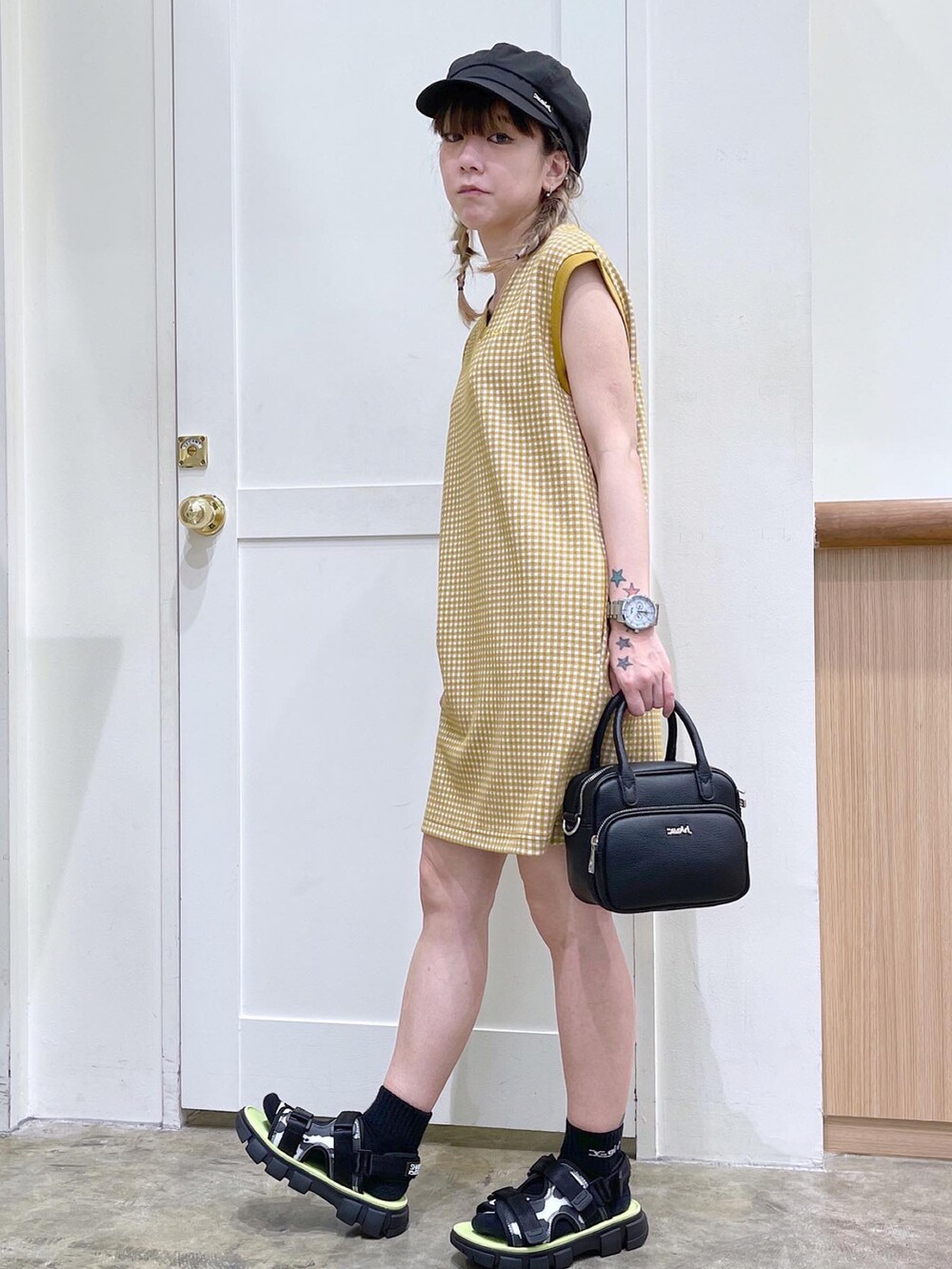 ベージュ系のワンピース、ブラック系のショルダーバッグ、ブラック系のサンダルを着用したレディースの夏コーディネートの2枚目の写真