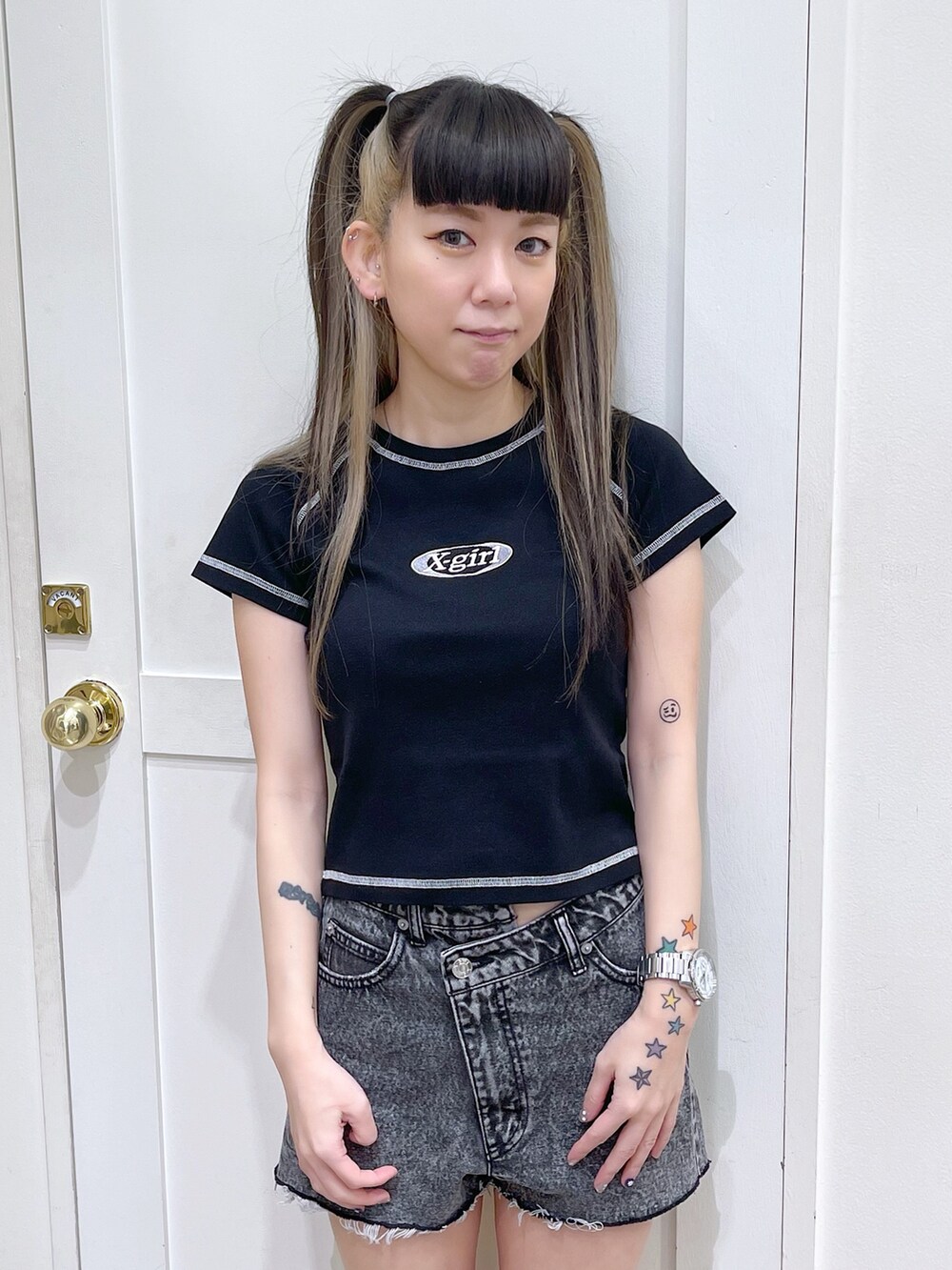 ブラック系のTシャツ/カットソー、ブラック系のデニムパンツ、ホワイト系のスニーカーを着用したレディースの夏コーディネートの5枚目の写真