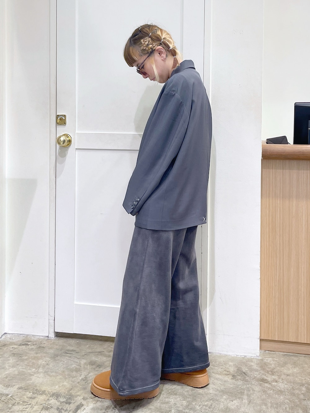 グレー系のテーラードジャケット、ブラック系のスウェットパンツ、ブラック系のショルダーバッグを着用したレディースの冬コーディネートの3枚目の写真