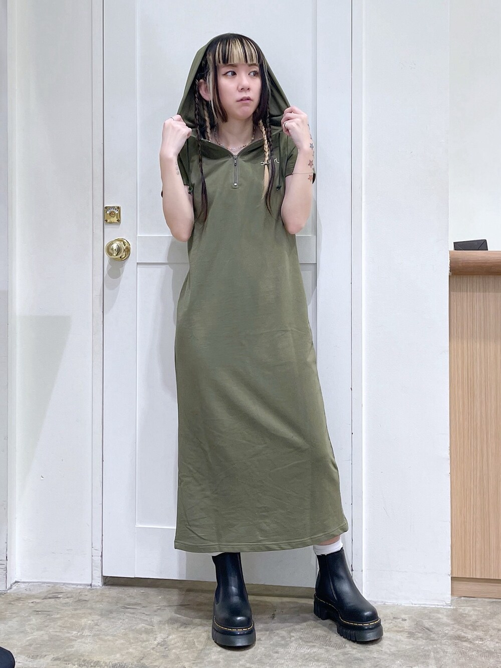 グレー系のトートバッグ、グリーン系のワンピース、ブラック系のブーツを着用したレディースの春コーディネートの3枚目の写真