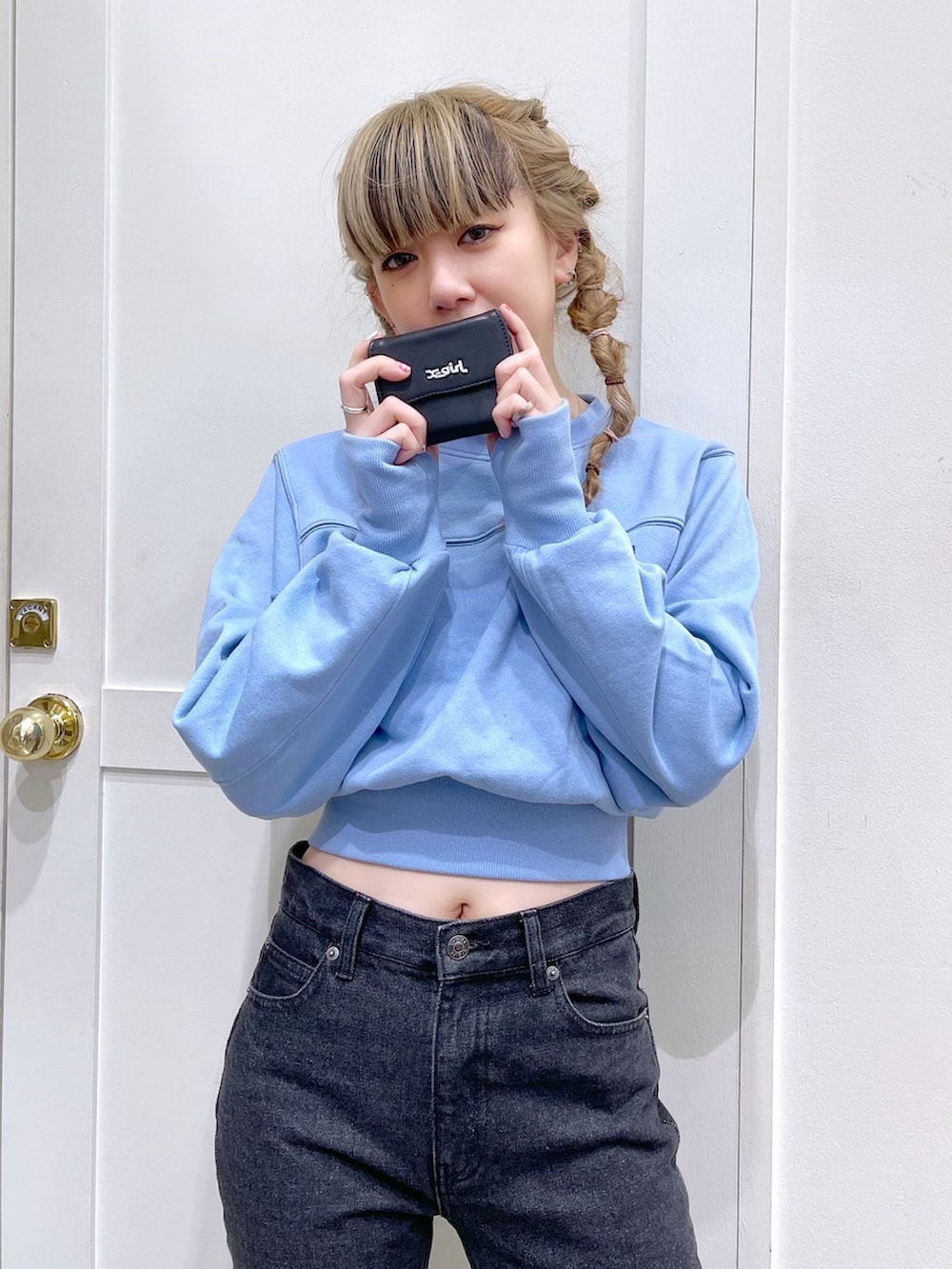 ブルー系のスウェット、ブラック系のデニムパンツ、ブラック系の財布を着用したレディースの冬コーディネートの2枚目の写真