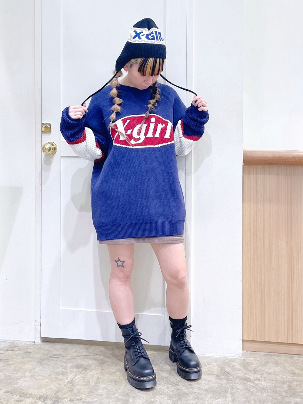 ブルー系のニット/セーター、グリーン系のスカート、ブラック系のブーツを着用したレディースの冬コーディネートの2枚目の写真