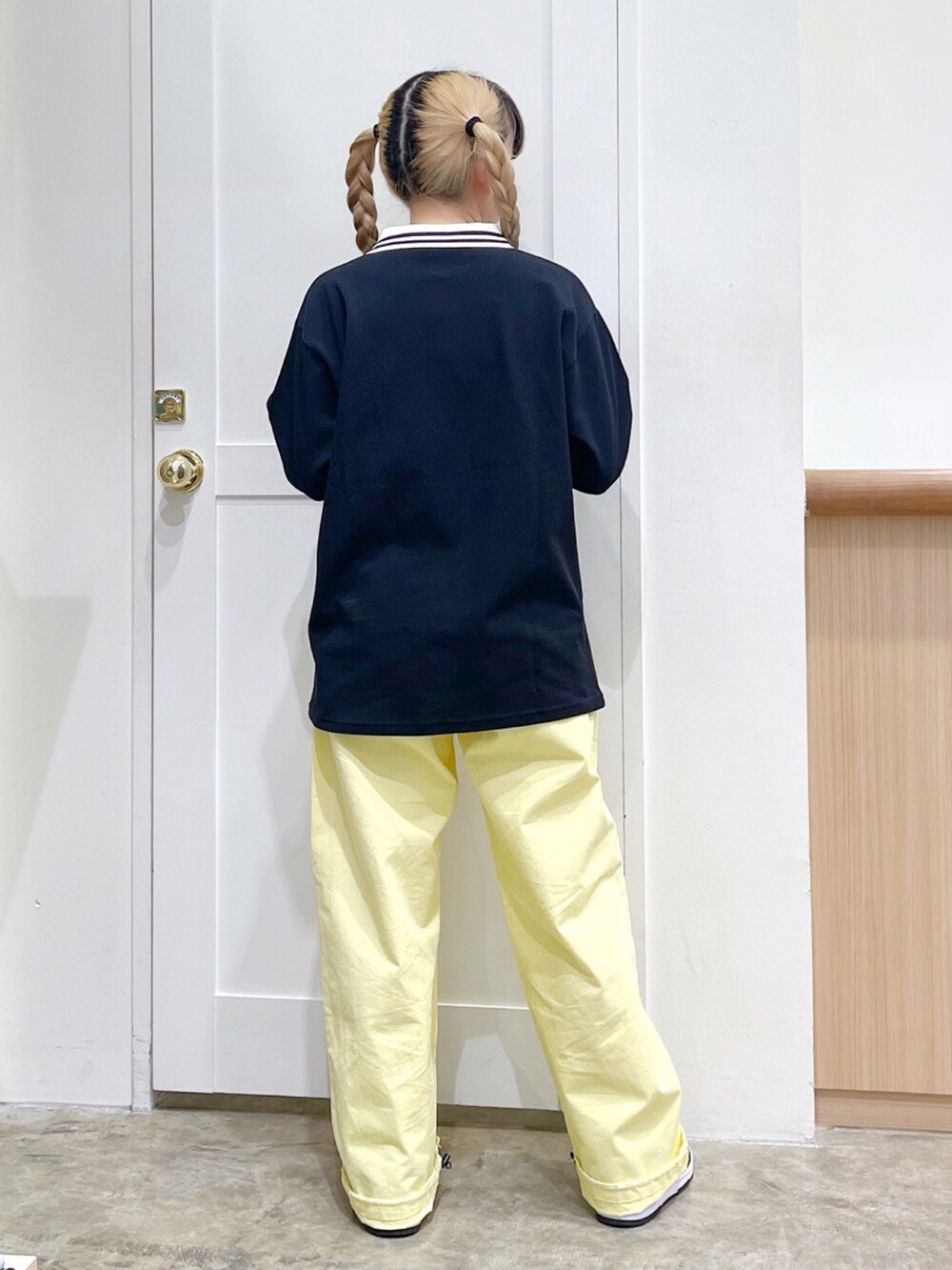 ブラック系のTシャツ/カットソー、イエロー系のその他パンツ、ブラック系のショルダーバッグを着用したレディースの春コーディネートの4枚目の写真