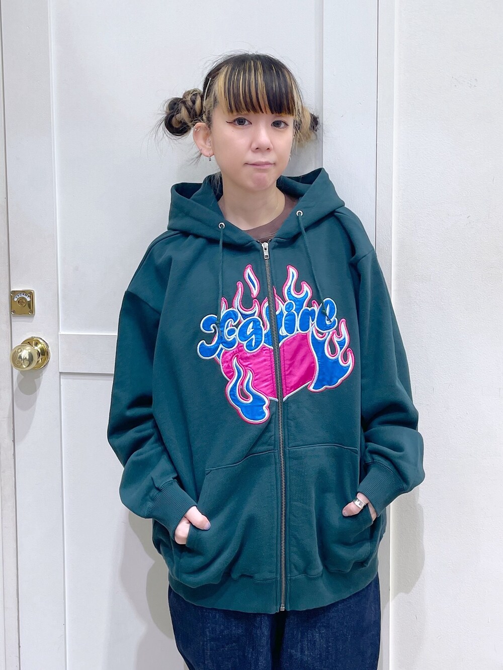 グリーン系のパーカー、ブルー系のサロペット/オーバーオール、ブラウン系のTシャツ/カットソーを着用したレディースの冬コーディネートの2枚目の写真