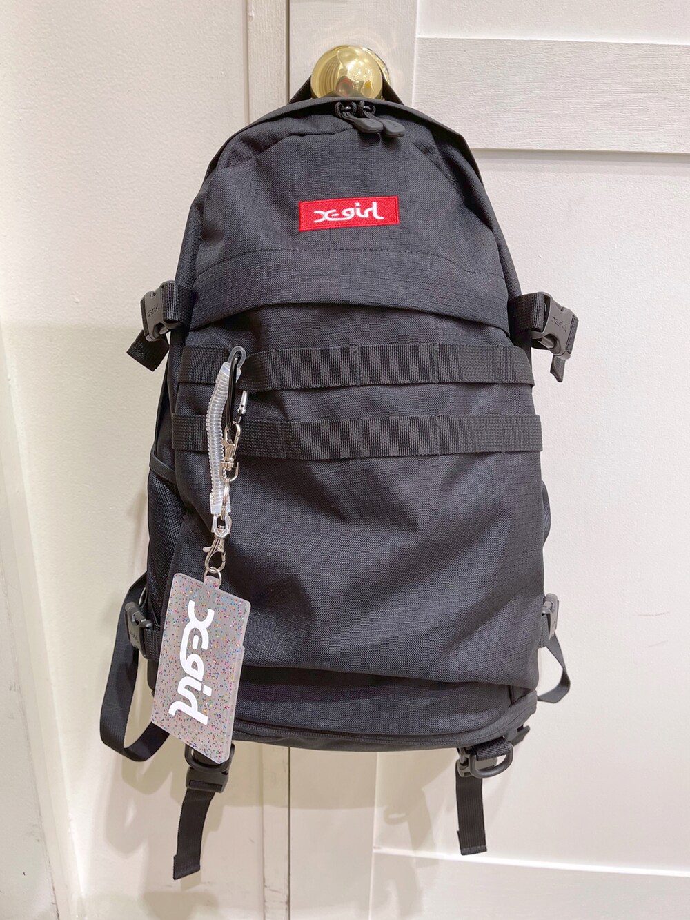 グレー系のタンクトップ、レッド系のバックパック/リュック、ブルー系のカーゴパンツを着用したレディースの夏コーディネートの2枚目の写真