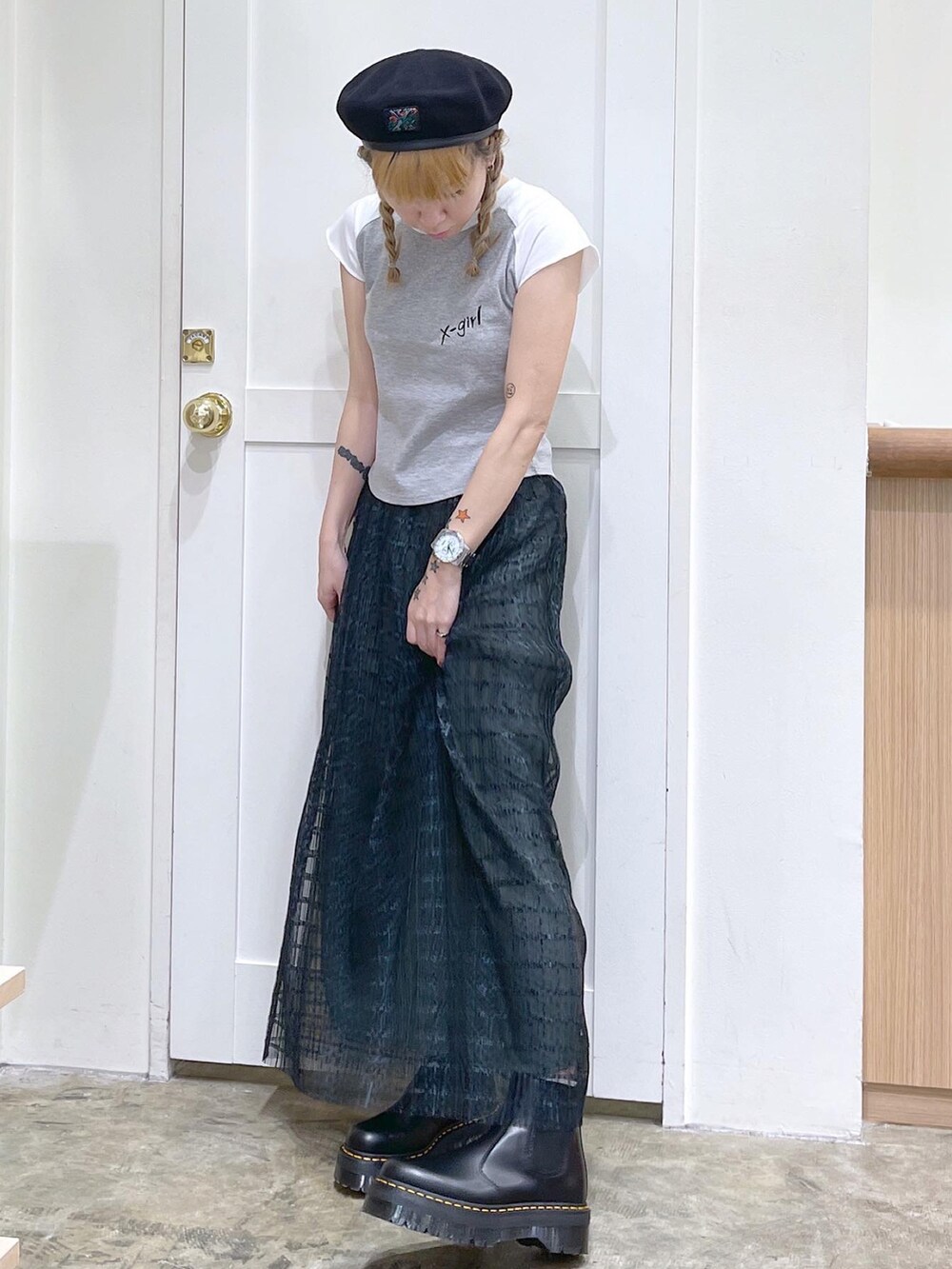 グレー系のTシャツ/カットソー、グリーン系のスカート、ブラック系のブーツを着用したレディースの夏コーディネートの2枚目の写真