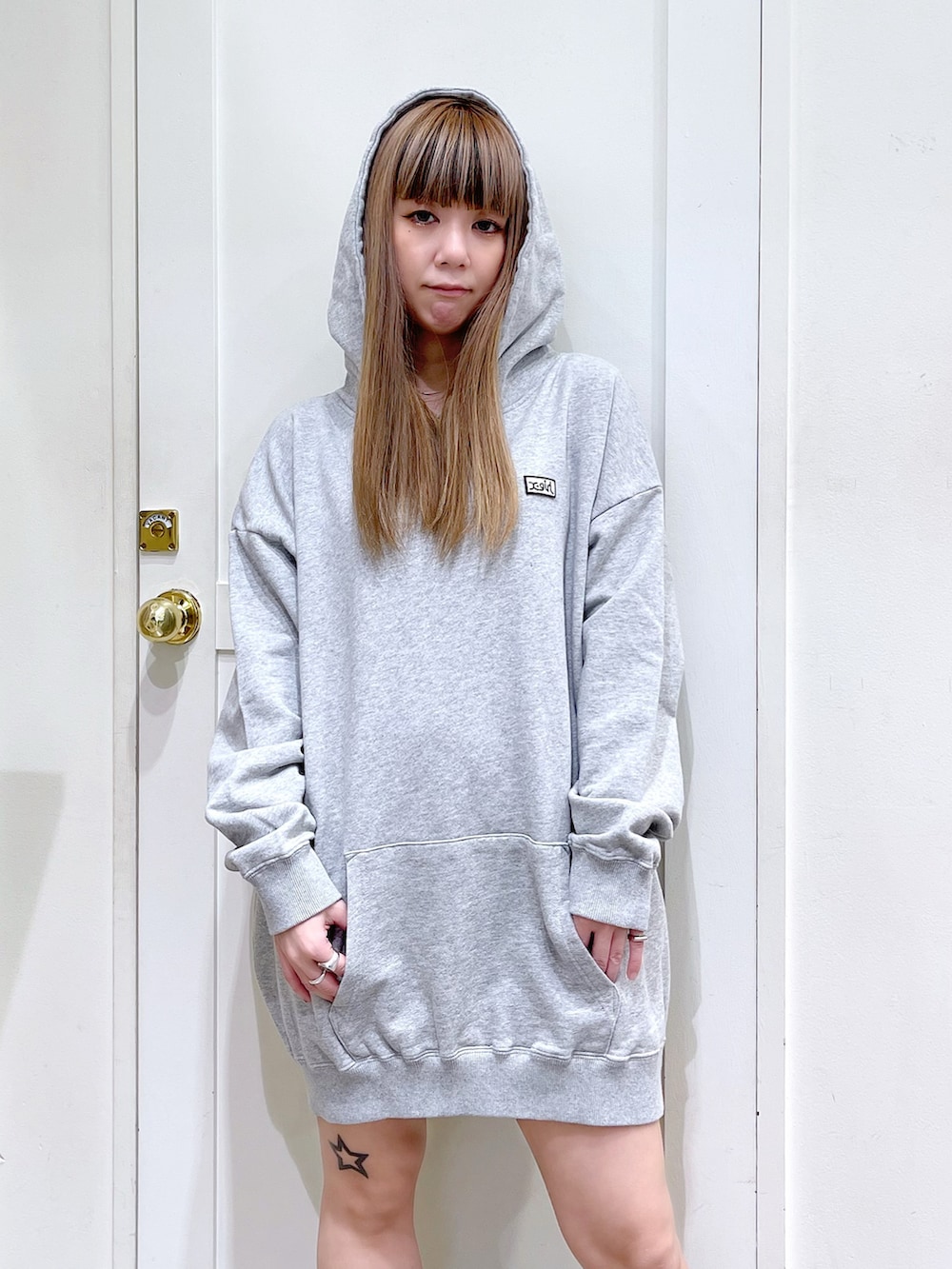 グレー系のパーカー、ブラック系のその他アウター、ホワイト系のショルダーバッグを着用したレディースの冬コーディネートの5枚目の写真