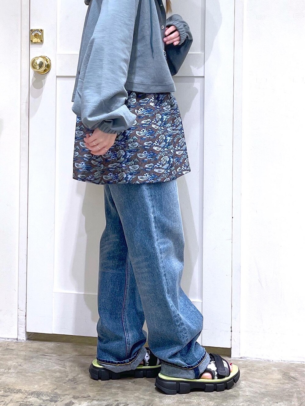 グリーン系のカーディガン/ボレロ、ブラウン系のチュニック、ホワイト系のタンクトップを着用したレディースの夏コーディネートの3枚目の写真