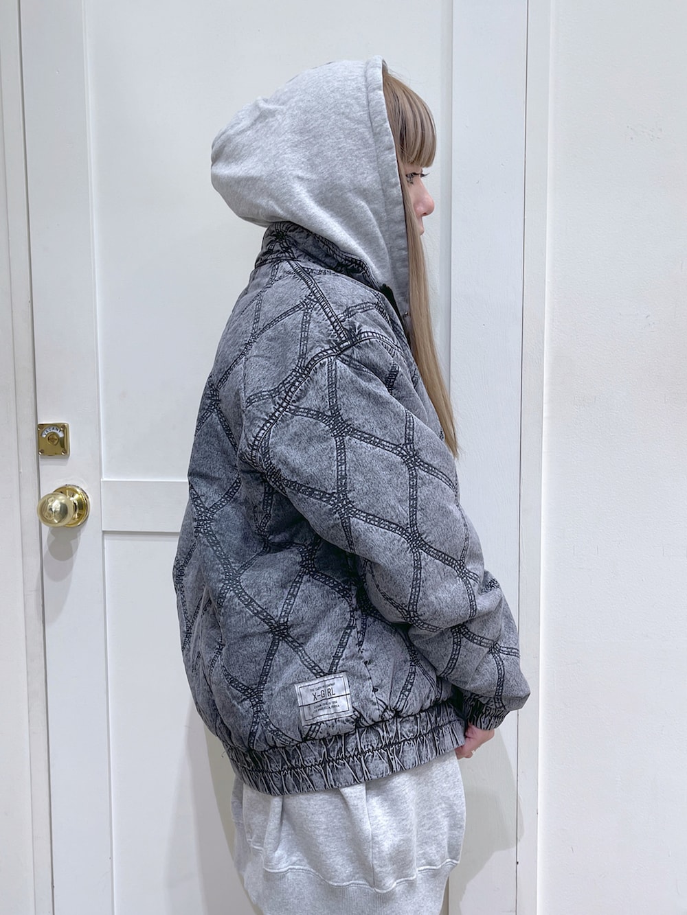 グレー系のパーカー、ブラック系のその他アウター、ホワイト系のショルダーバッグを着用したレディースの冬コーディネートの4枚目の写真