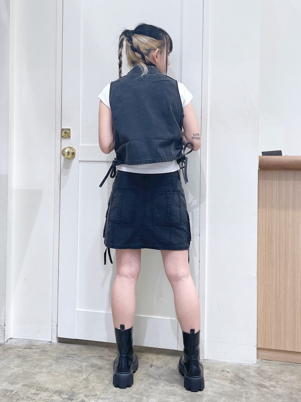 ブラック系のベスト、ブラック系のスカート、ホワイト系のTシャツ/カットソーを着用したレディースの春コーディネートの5枚目の写真