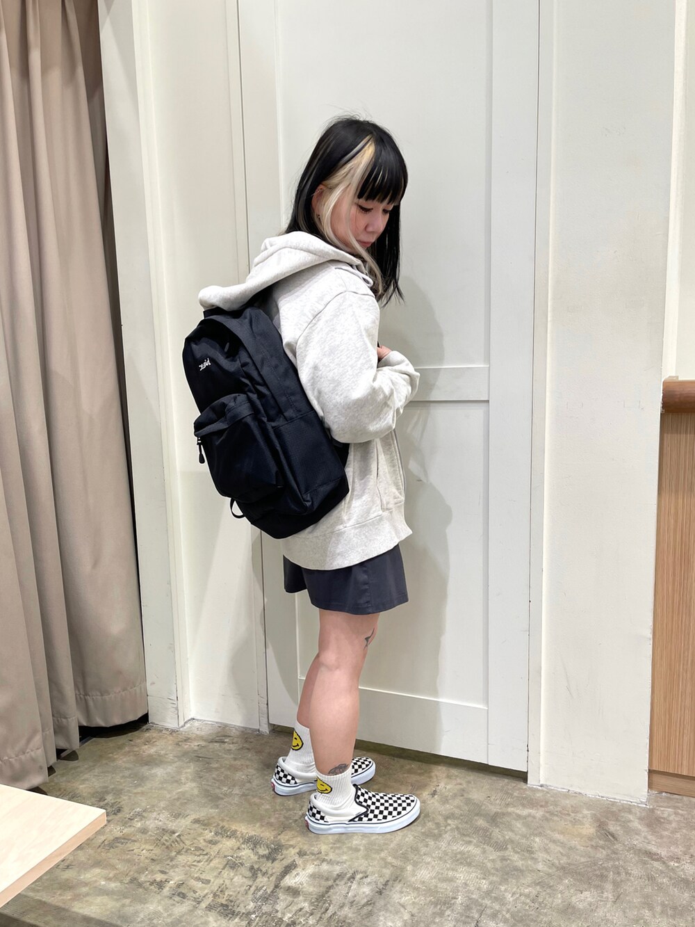 グレー系のワンピース、グレー系のパーカー、ブラック系のバックパック/リュックを着用したレディースの冬コーディネートの2枚目の写真