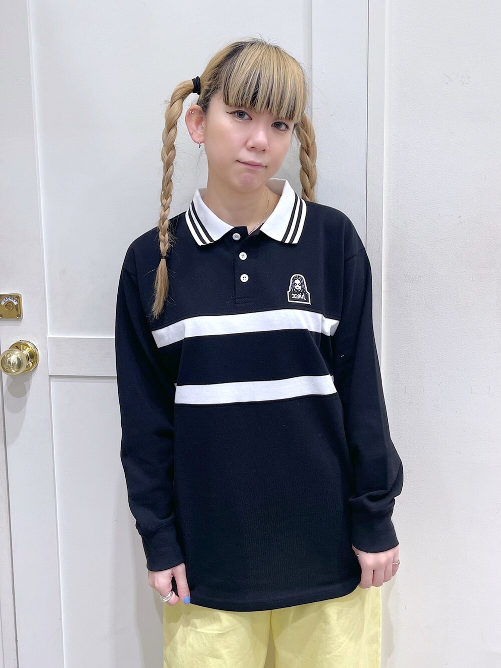 ブラック系のTシャツ/カットソー、イエロー系のその他パンツ、ブラック系のショルダーバッグを着用したレディースの春コーディネートの5枚目の写真