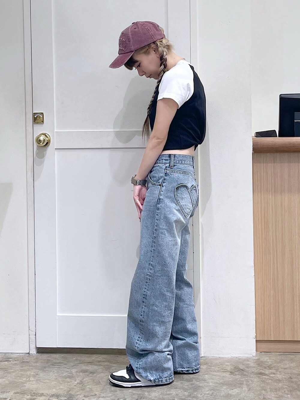 ブラック系のTシャツ/カットソー、ブルー系のデニムパンツ、レッド系のキャップを着用したレディースの夏コーディネートの3枚目の写真