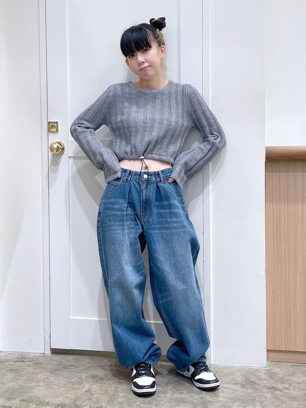 ブルー系のダウンジャケット/コート、グレー系のニット/セーター、ブルー系のデニムパンツを着用したレディースの秋コーディネートの6枚目の写真