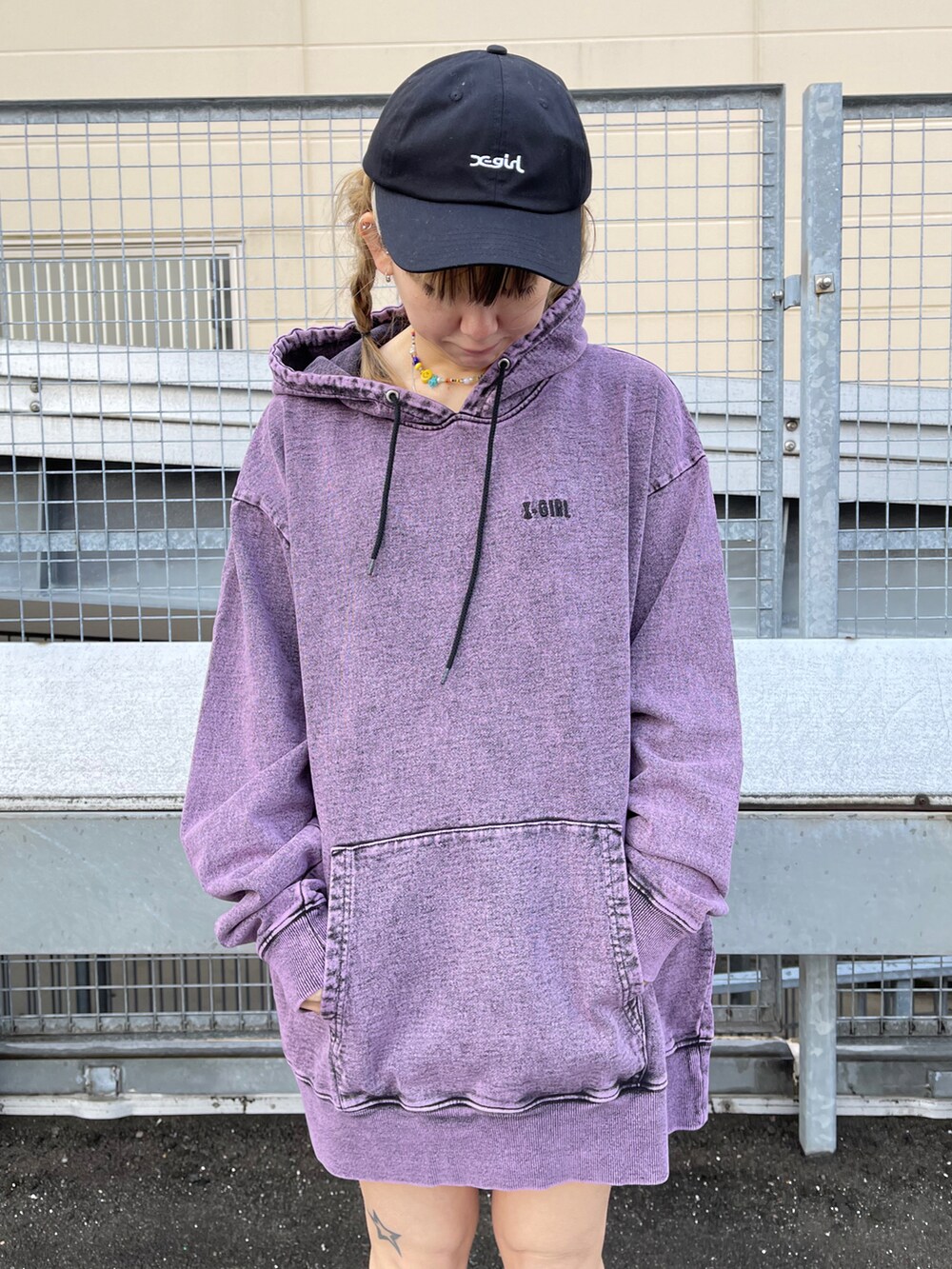 ピンク系のパーカー、ブラック系のボディバッグ/ウエストポーチ、ブラック系のキャップを着用したレディースの冬コーディネートの2枚目の写真