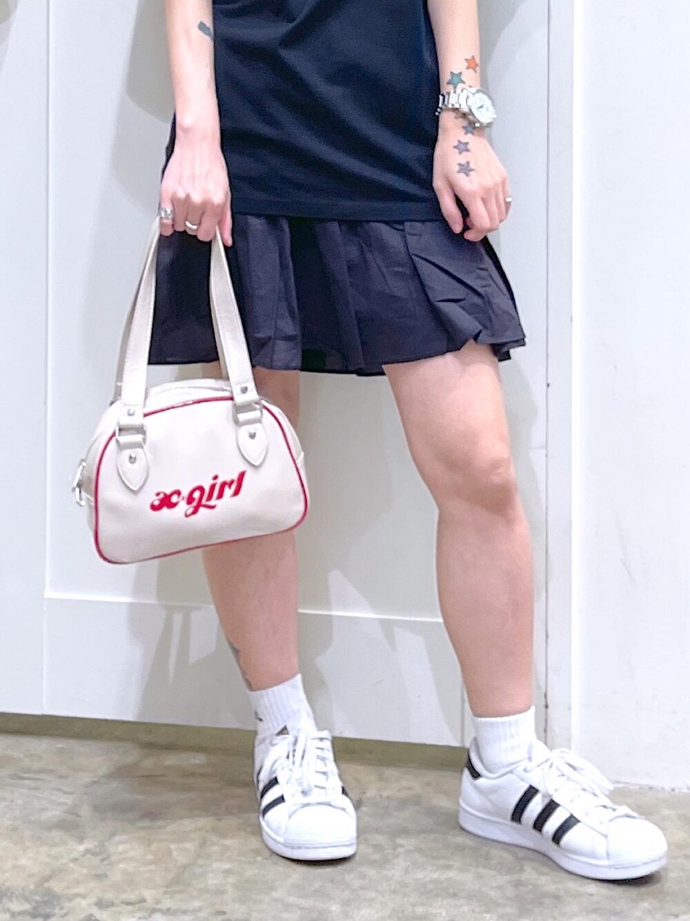 ブラック系のTシャツ/カットソー、ブラック系のスカート、ホワイト系のボストンバッグを着用したレディースの夏コーディネートの5枚目の写真