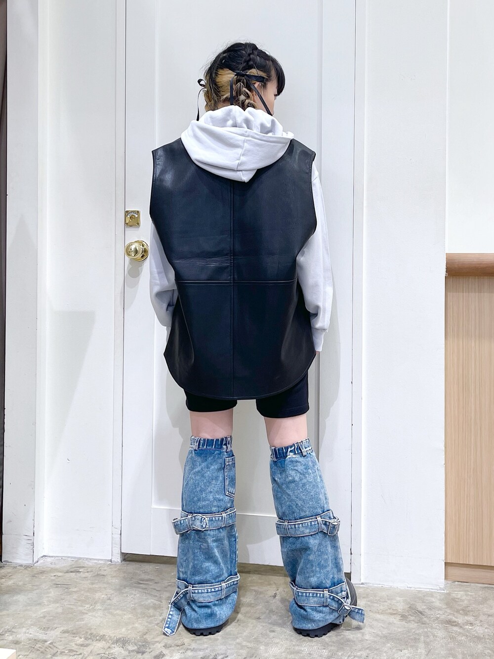 グレー系のパーカー、ブラック系のベスト、ブラック系のスウェットパンツを着用したレディースの秋コーディネートの4枚目の写真