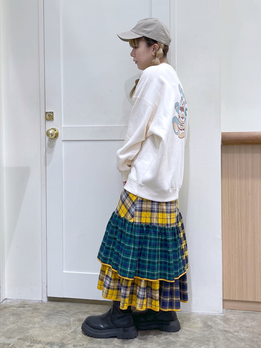 ホワイト系のスウェット、イエロー系のスカート、ベージュ系のキャップを着用したレディースの秋コーディネートの4枚目の写真