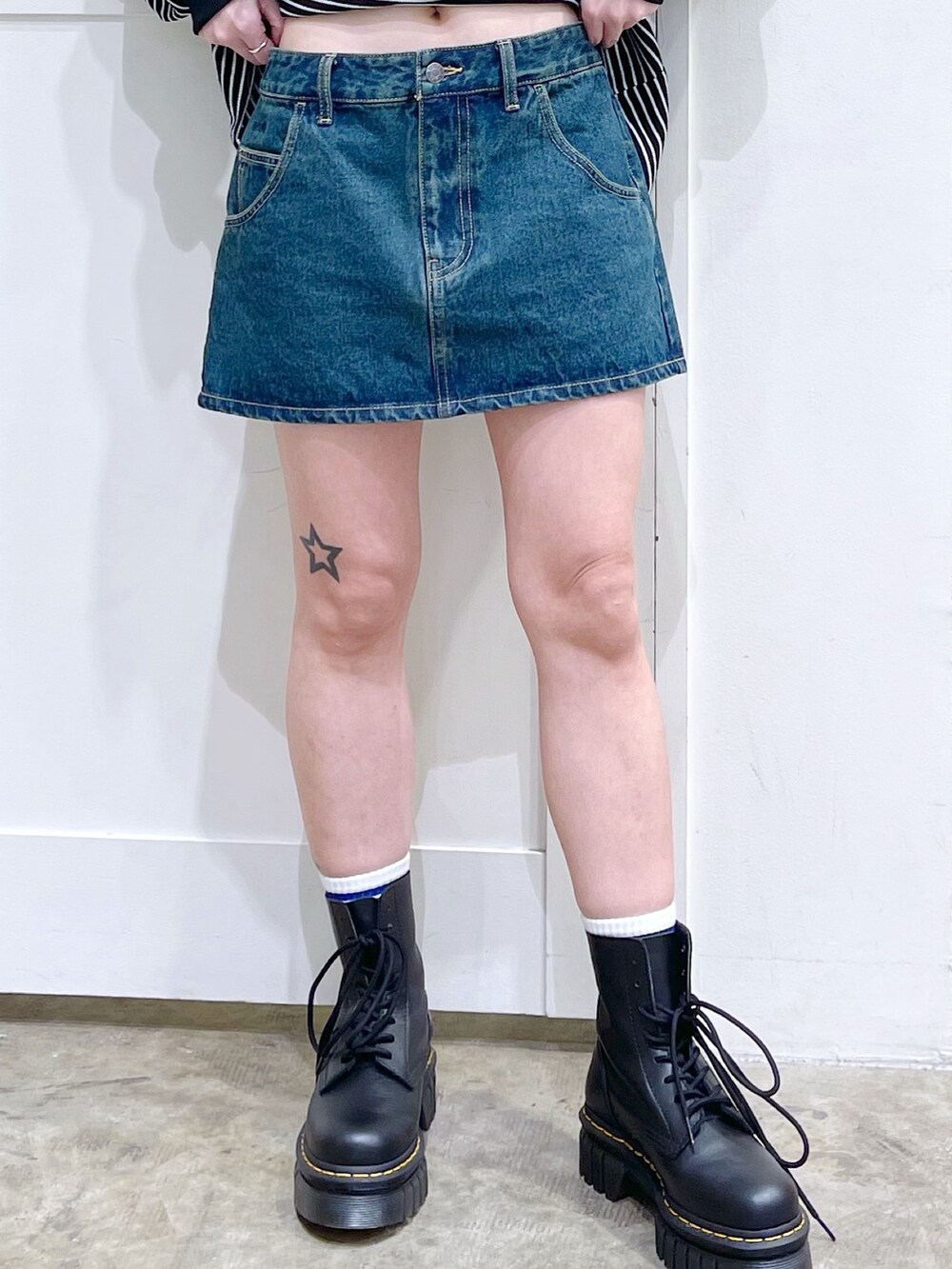 グレー系のブルゾン、ホワイト系のTシャツ/カットソー、ブルー系のスカートを着用したレディースの冬コーディネートの6枚目の写真