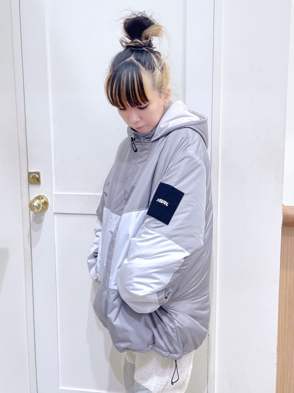 グレー系のマウンテンパーカー、ブラック系のスウェット、ホワイト系のその他パンツを着用したレディースの秋コーディネートの3枚目の写真