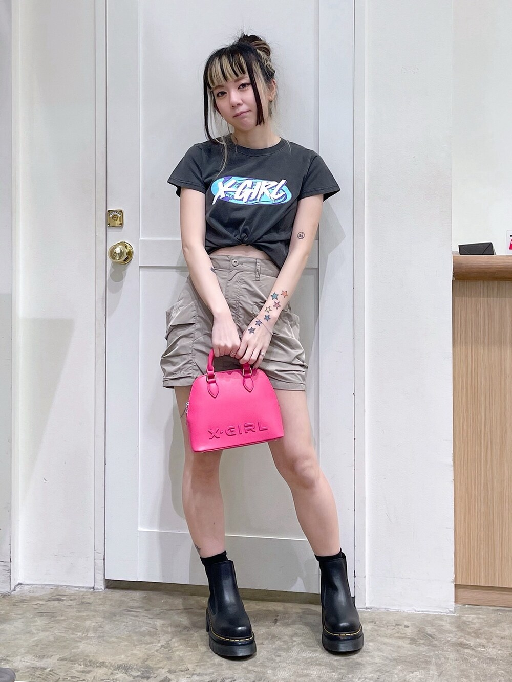 ブラック系のTシャツ/カットソー、ベージュ系のスカート、ピンク系のショルダーバッグを着用したレディースの春コーディネートの2枚目の写真