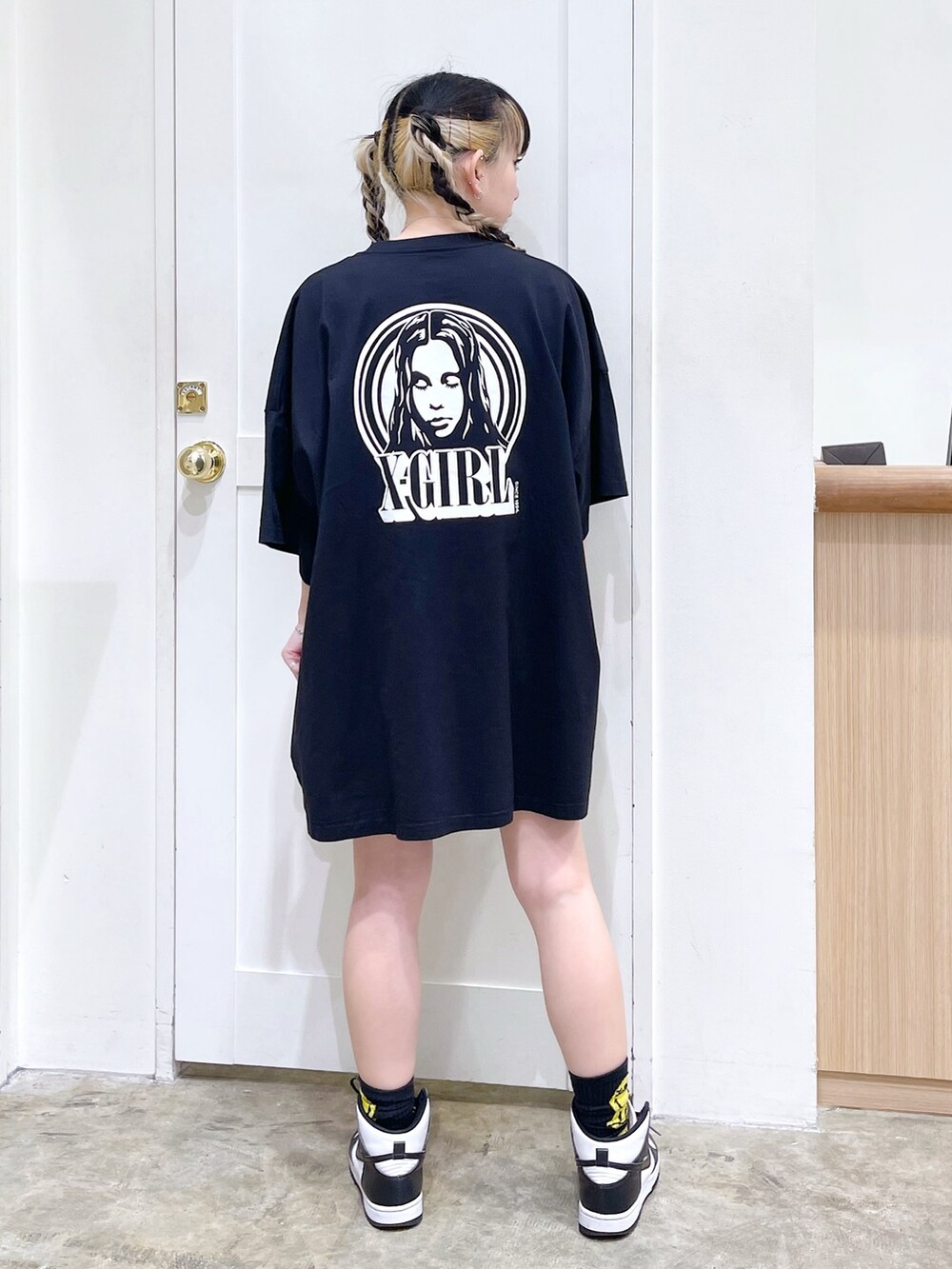 ブラック系のワンピース、ピンク系のショルダーバッグ、ベージュ系の財布を着用したレディースの春コーディネートの2枚目の写真