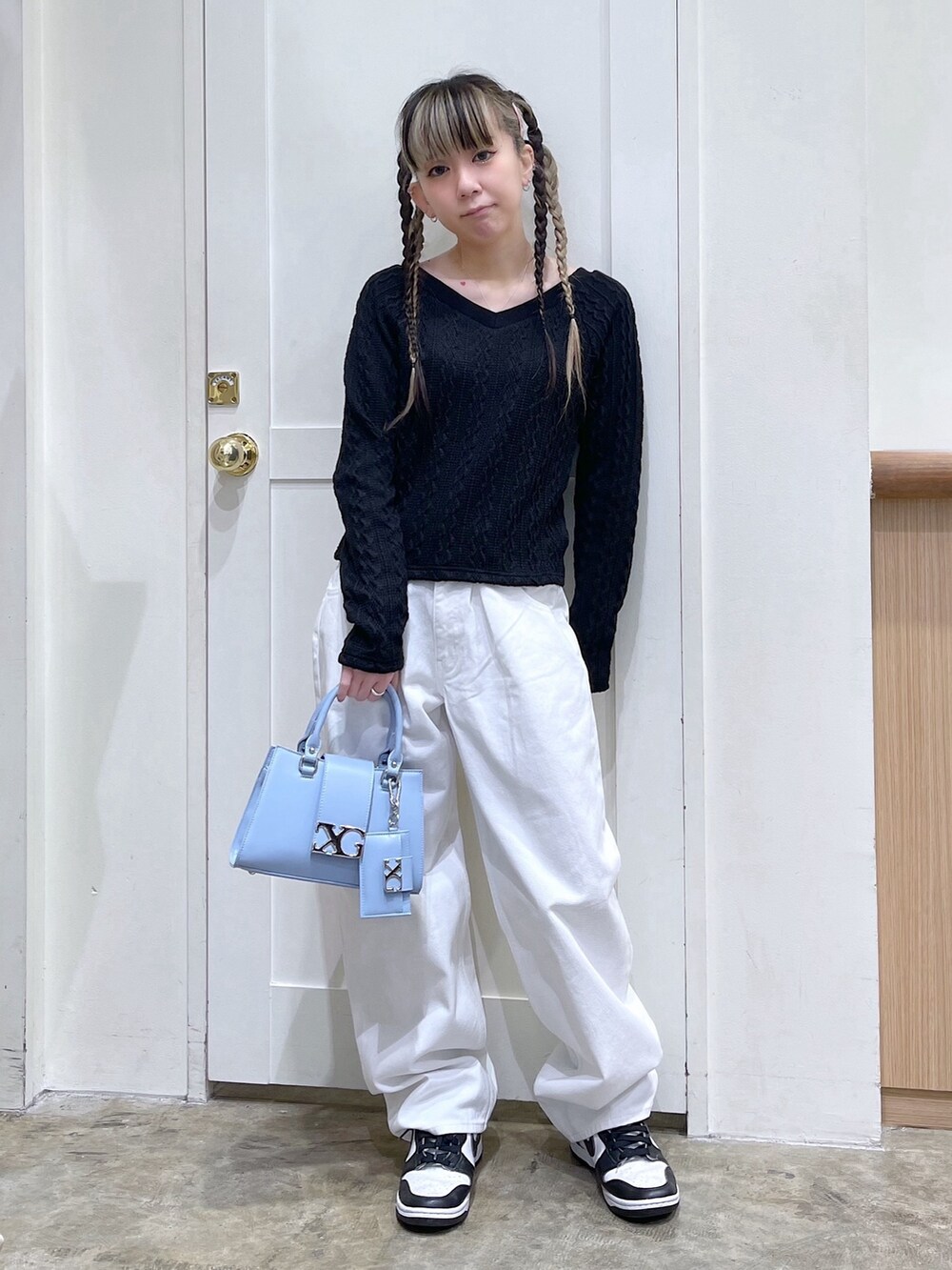 ブラック系のTシャツ/カットソー、ホワイト系のデニムパンツ、ブルー系のショルダーバッグを着用したレディースの冬コーディネートの2枚目の写真