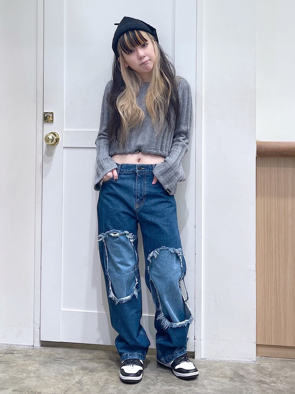 グレー系のニット/セーター、ブルー系のデニムパンツ、ブラック系のニットキャップ/ビーニーを着用したレディースの秋コーディネートの2枚目の写真