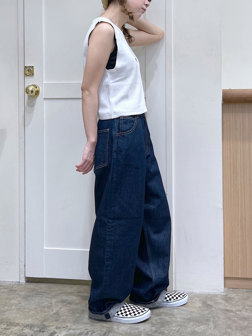 ホワイト系のタンクトップ、ブルー系のデニムパンツ、ベージュ系のハンチング/ベレー帽を着用したレディースの夏コーディネートの3枚目の写真