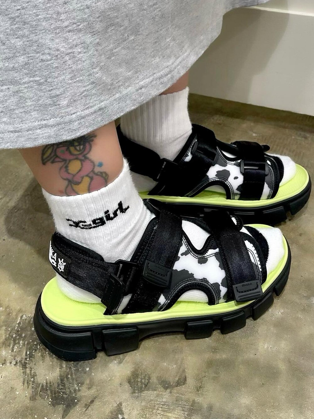 ブラック系のTシャツ/カットソー、グレー系のワンピース、ブラック系のサンダルを着用したレディースの春コーディネートの3枚目の写真