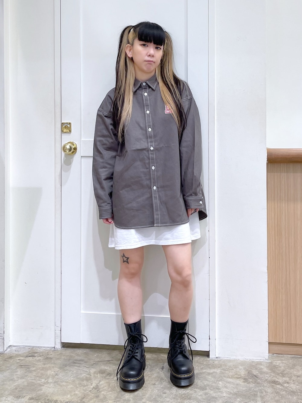 ブラック系のダウンベスト、グリーン系のシャツ/ブラウス、ホワイト系のワンピースを着用したレディースの秋コーディネートの4枚目の写真