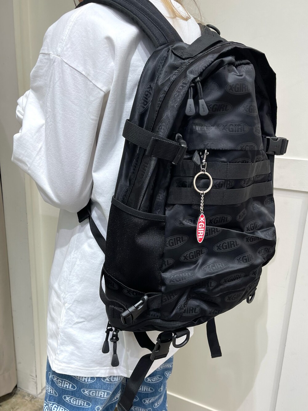 ホワイト系のTシャツ/カットソー、ブルー系のデニムパンツ、ブラック系のバックパック/リュックを着用したレディースの冬コーディネートの2枚目の写真