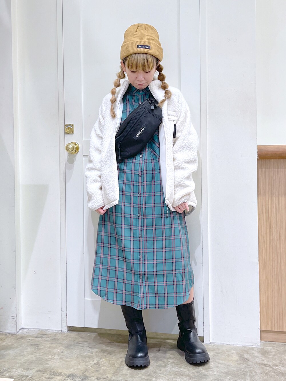 ホワイト系のブルゾン、グリーン系のワンピース、ブラック系のボディバッグ/ウエストポーチを着用したレディースの秋コーディネートの2枚目の写真