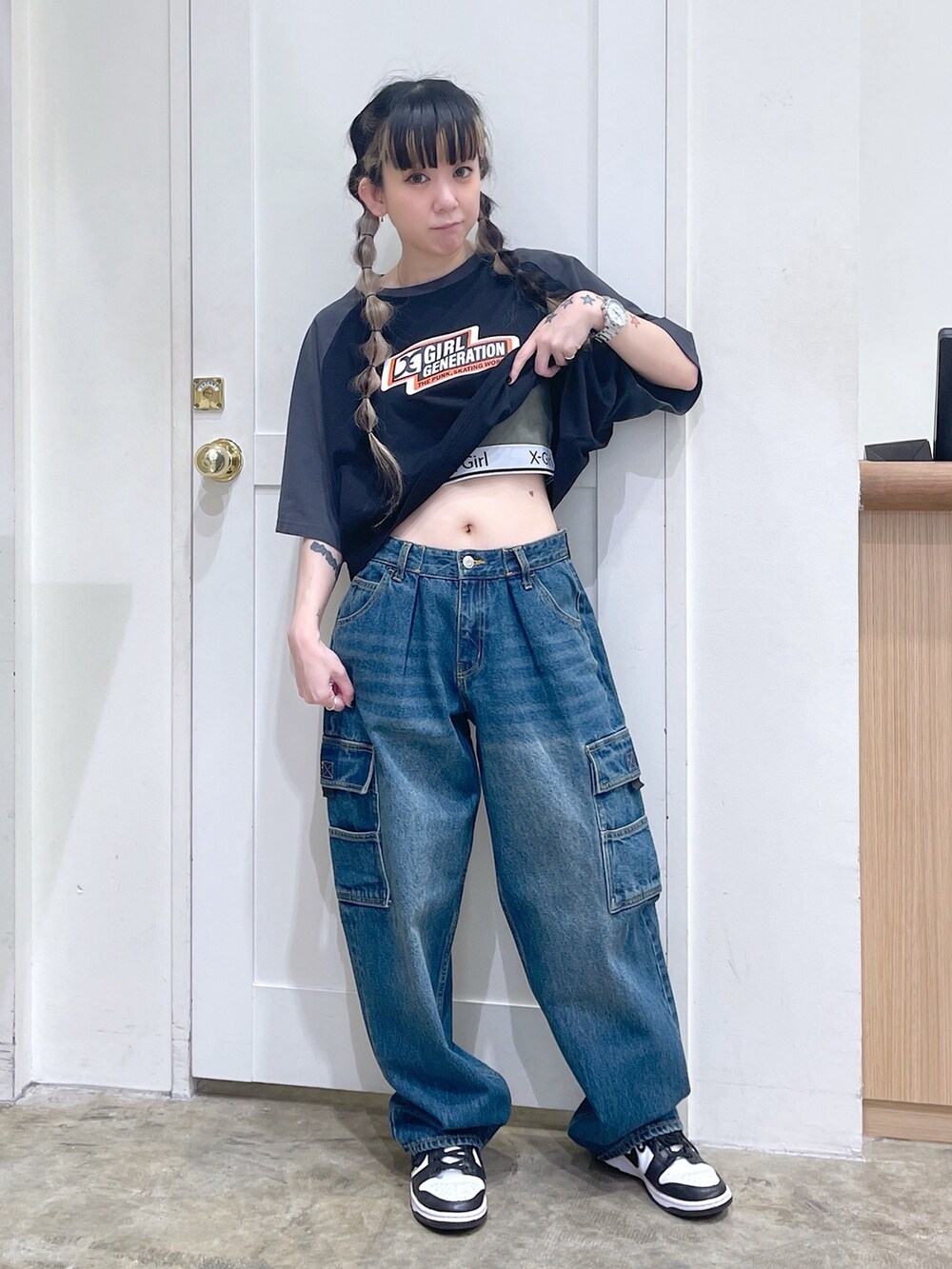 ブラック系のTシャツ/カットソー、ブルー系のカーゴパンツ、グリーン系のタンクトップを着用したレディースの夏コーディネートの2枚目の写真