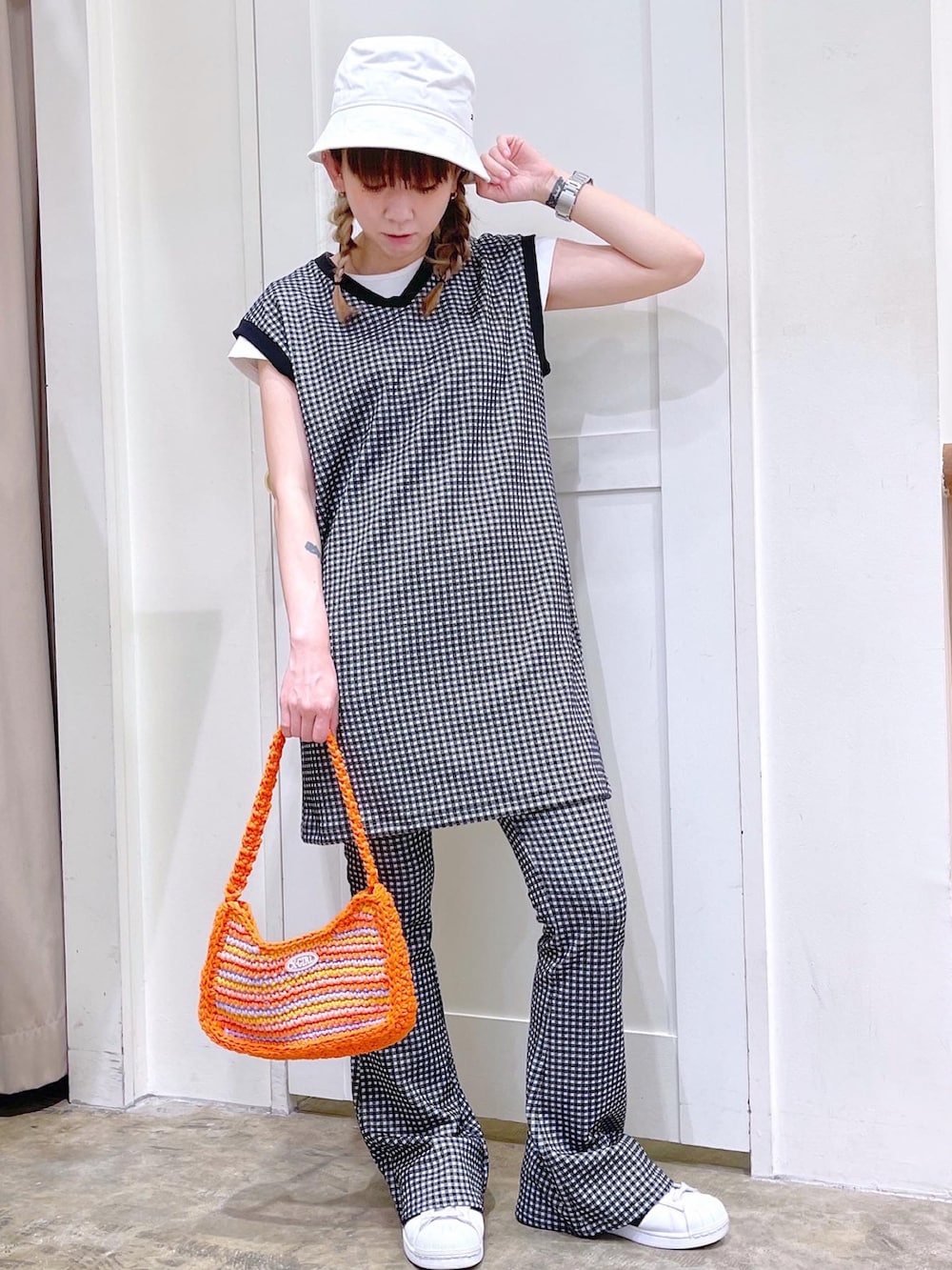 ブラック系のワンピース、ブラック系のその他パンツ、オレンジ系のハンドバッグを着用したレディースの夏コーディネートの2枚目の写真