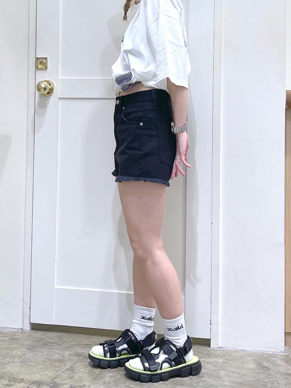 ホワイト系のTシャツ/カットソー、ブラック系のデニムパンツ、ブラック系のサンダルを着用したレディースの夏コーディネートの4枚目の写真